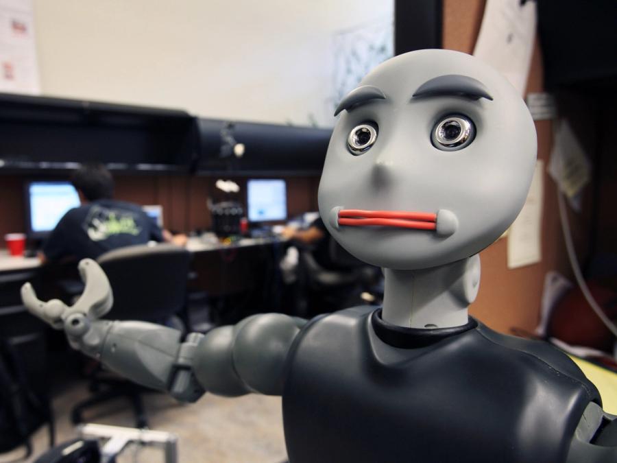 Close up of a robot gesturing to the space it is in.