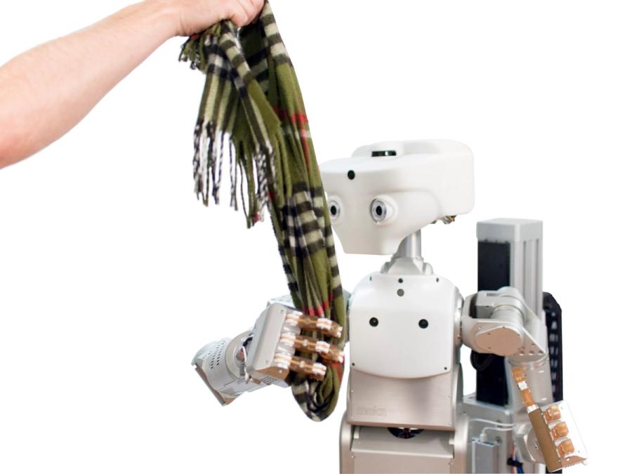A hand coming into the frame holds a green scarf, which the robot is also gripping one hand.ping