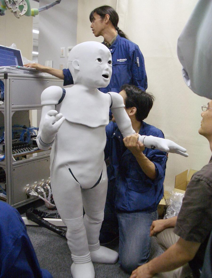People gather around the child sized robot.