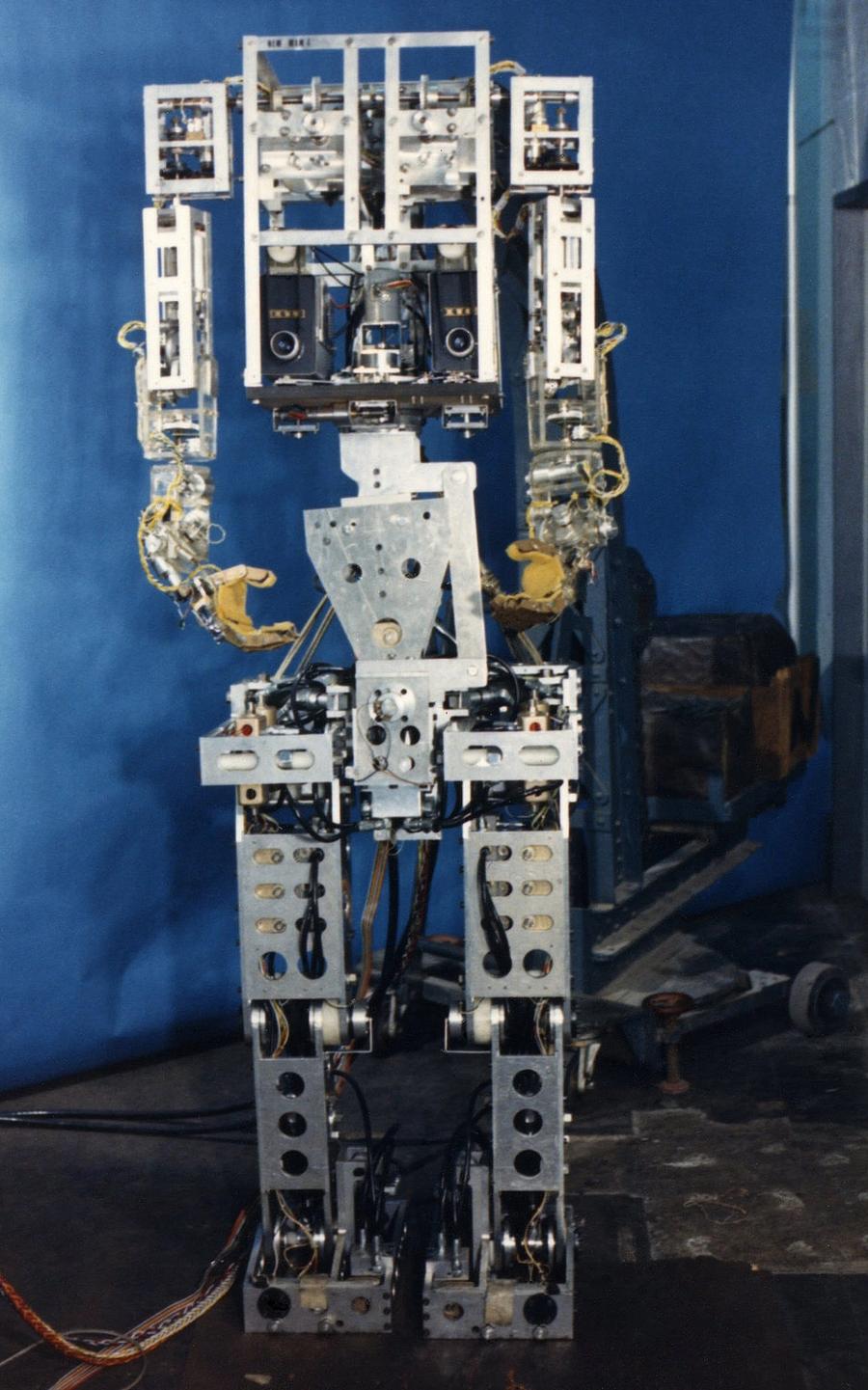 A complex looking humanoid with a metallic frame full of wires and electronics.