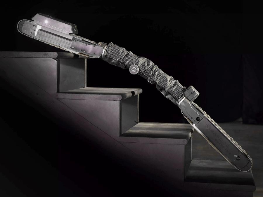 A black snake-like robot climbs a set of stairs.