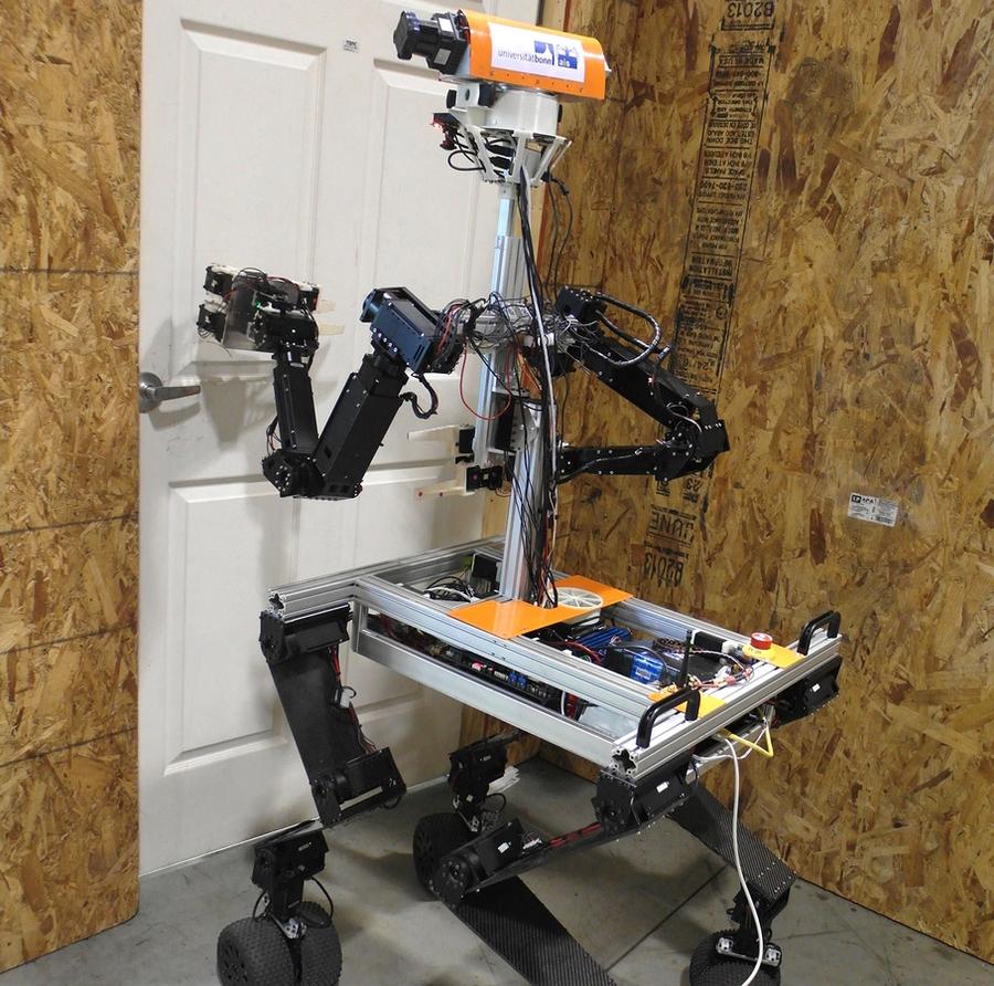 A four-wheeled mobile robot with a wide base, slim torso, arms with gripper hands, and an orange horizontal bar with sensors for a head moves to open a door.